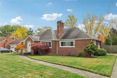 View of front facade with brick siding, a chimney, and roof with shingles