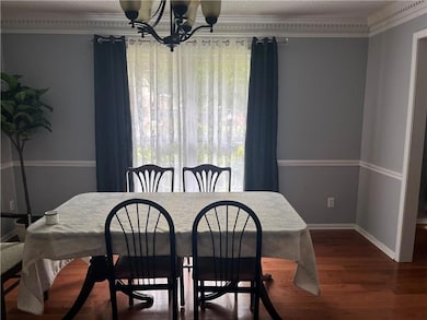 Dining area with a chandelier, healthy amount of natural light, and wood finished floors