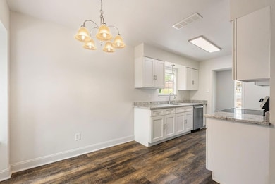 Kitchen with a sink, a chandelier, stainless steel