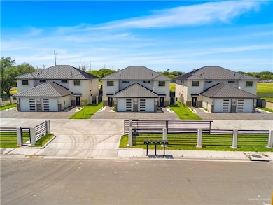 View of front of property with concrete driveway, a front lawn, metal roof, and a fenced front yard
