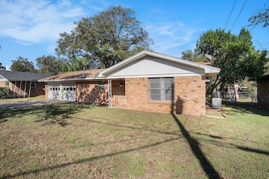 Ranch-style home featuring brick siding, an attached garage, and driveway