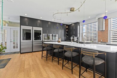 Kitchen with dark cabinets, oven, refrigerator wit