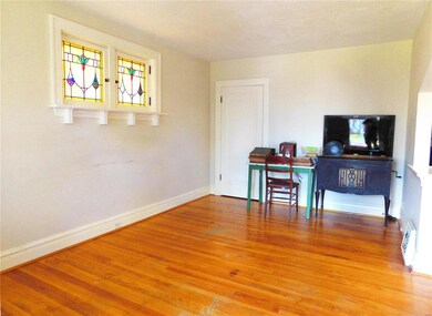 Large Living Room with wood flooring and beautiful stained glass windows.