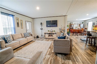 Living area with wood finished floors and crown molding