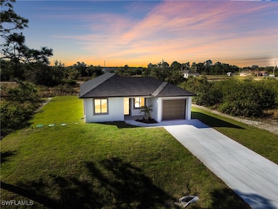 View of front of property featuring a lawn and a g