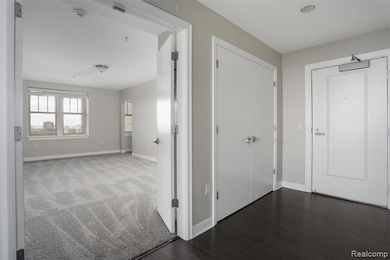 Corridor featuring baseboards and dark wood-type flooring