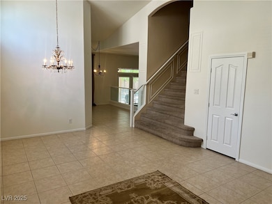 Staircase featuring tile patterned flooring, a chandelier, and a high ceiling