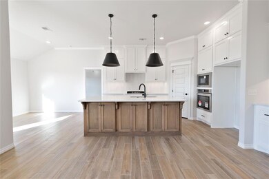 Kitchen featuring white cabinetry, a large island,