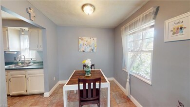 Dining room with light tile floors, leading to kitchen