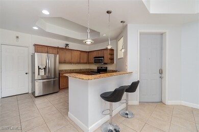 Kitchen featuring a breakfast bar, a tray ceiling,