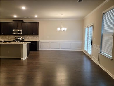 Kitchen featuring dark brown cabinetry, a chandeli