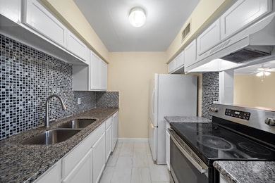 Galley kitchen with granite counters, dishwasher,