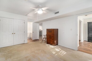 Bedroom featuring attic access, light colored carpet, a closet