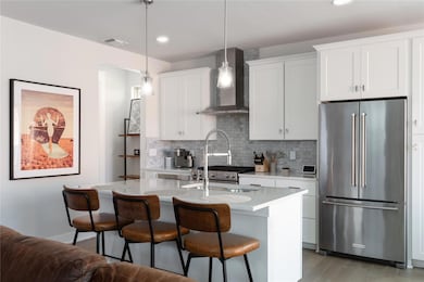 Kitchen featuring freestanding refrigerator, wall