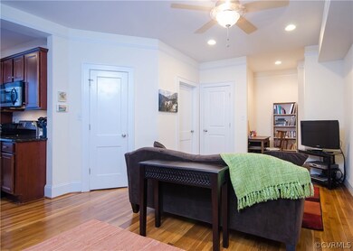 A view of the LIVING ROOM with coat closet, small pantry, ceiling fan with light, and a functional office nook.