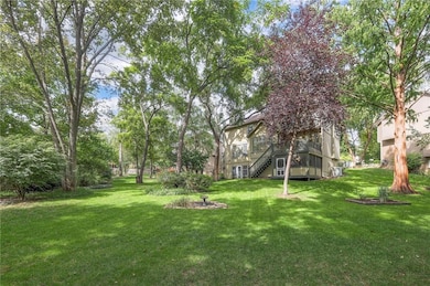 View of grassy yard with a deck and stairway