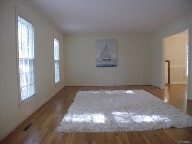 Living room has oak floor and crown molding