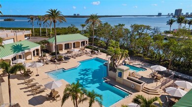Community pool with fence, a water view, and a pat