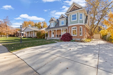 View of front facade with covered porch, brick siding, and a front lawn