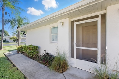 Doorway to property featuring stucco siding