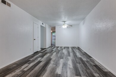 Spare room featuring dark wood-type flooring, a textured ceiling, and a ceiling fan