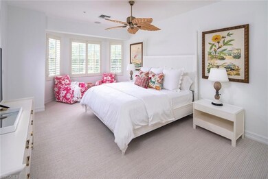 Bedroom with light colored carpet, a ceiling fan, and baseboards