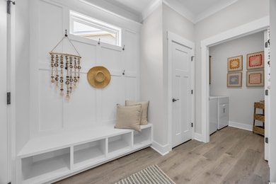 Mudroom featuring light wood-style flooring and washer and dryer
