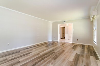 Empty room featuring light hardwood / wood-style flooring and ornamental molding