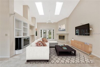 LIVING ROOM with FRENCH DOORS leading to the SCREENED LANAI. Virtually staged.