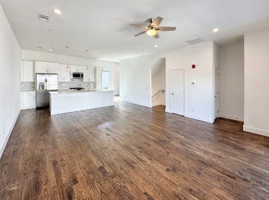 Unfurnished living room featuring recessed lighting, ceiling fan, and dark wood-style floors