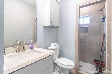 Full bath featuring a stall shower, vanity, and toilet