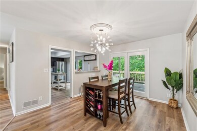 Dining room featuring wood finished floors, a chandelier, and baseboards
