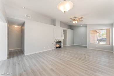 Unfurnished living room featuring a ceiling fan, l