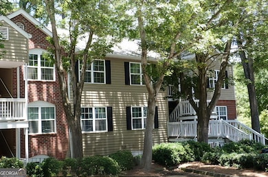 Welcoming front entrance featuring natural shade and easily navigable stairs, with the upper level accessible via a single flight of stairs.