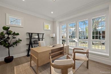 Home office with light wood-type flooring, ornamental molding, and recessed lighting