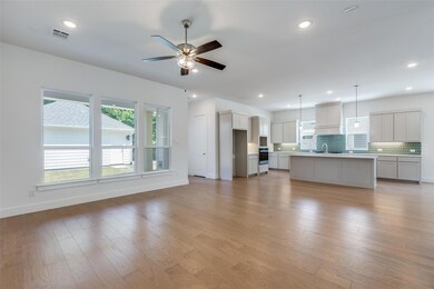 Unfurnished living room featuring ceiling fan, sin