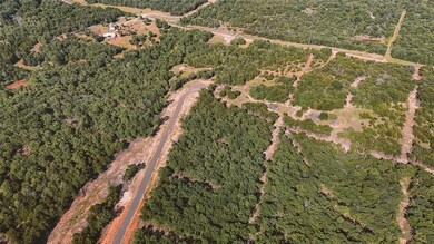 Aerial view of property and surrounding area featuring a heavily wooded area