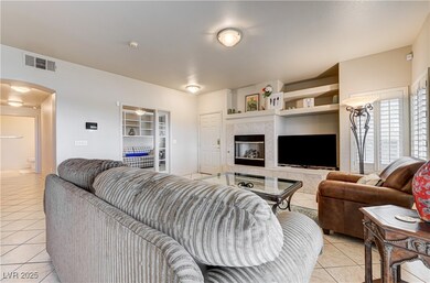 Living area featuring light tile patterned flooring, arched walkways, and a fireplace