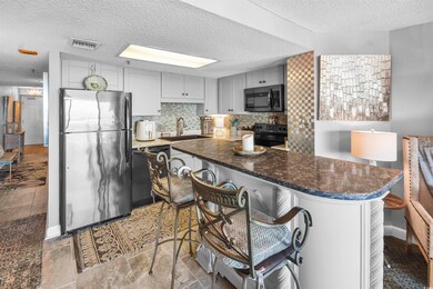 Kitchen featuring visible vents, freestanding refr