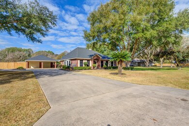 Long, double-wide driveway with the concrete extending around to the back of the fence.