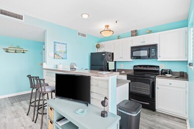 Kitchen featuring white cabinetry, light hardwood 