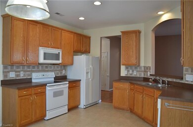 Kitchen with backplash and abundant cabinets.  Pretty opening to Great room.