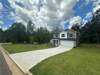 View of front facade featuring concrete driveway, a garage, and a front lawn