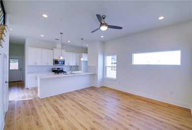 Kitchen with a peninsula, light countertops, tast
