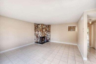 Large living room with tile floors, stone fireplac