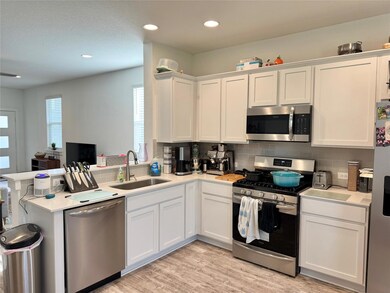 Kitchen with stainless steel appliances, white ca