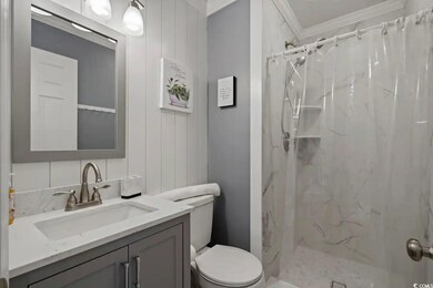 Bathroom with toilet, a marble finish shower, crown molding, and vanity