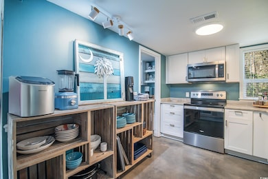Kitchen featuring visible vents, white cabinets, s