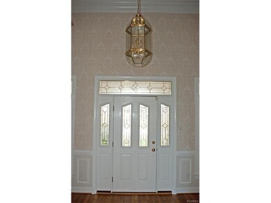 Grand foyer with beautiful door, sidelights and tr