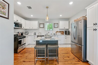 Kitchen with pendant lighting, light hardwood / wo